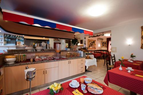 a large kitchen with a table in a restaurant at Hotel Dischma - FREE BUS AND TRAIN TICKET in Lugano