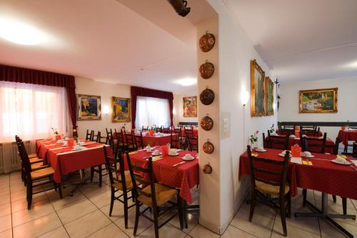 a restaurant with red tables and chairs in a room at Hotel Dischma - FREE BUS AND TRAIN TICKET in Lugano