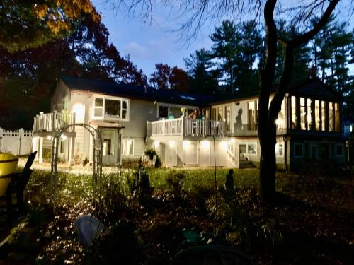 a large white house with people on the balcony at Clear Pond Suite in Plymouth