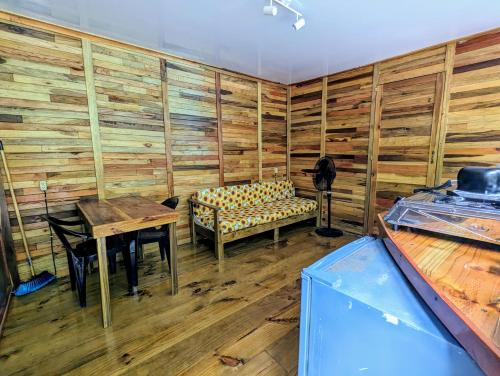 Arboura Eco Cabins في أوفيتا: غرفة مع طاولة وجلسة في غرفة مع جدران خشبية