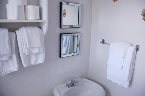 a bathroom with a sink and a mirror and towels at Rustico Acres Cottages in North Rustico