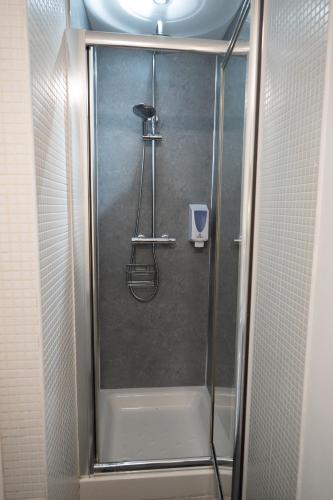 a shower with a glass door in a bathroom at Digbeth Aparthotel in Birmingham