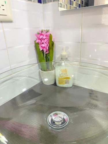a counter with a vase of flowers and a bottle of soap at casa vacacional en Anapoima in Anapoima