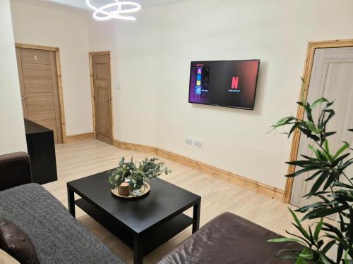 a living room with a couch and a table at Rooms in Manchester 6 minutes Drive to Victoria Station in Manchester