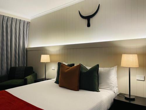 a hotel room with a large bed with pillows at The Black Bull Motel in Traralgon