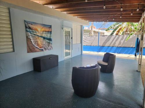 a room with two chairs and a painting on the wall at La Terraza cerca del aeropuerto in Carolina