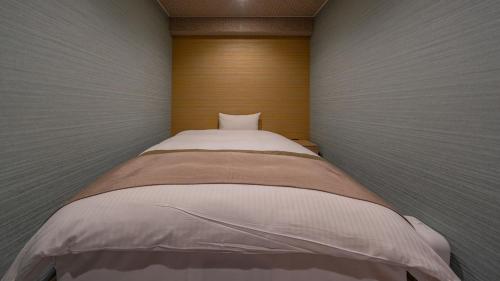 a small bed in a small room with at Residence Hotel Takayama Station in Takayama