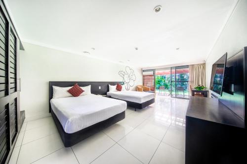 a bedroom with two beds and a flat screen tv at Tanoa Tusitala Hotel in Apia