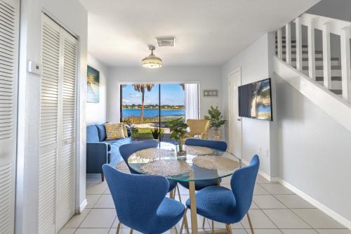 a dining room with a glass table and blue chairs at Charming Lakeview Retreat I in Orlando