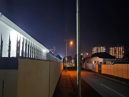 a city street at night with a wall and a street light w obiekcie Goshen Lodge Fitzroy w Kapsztadzie