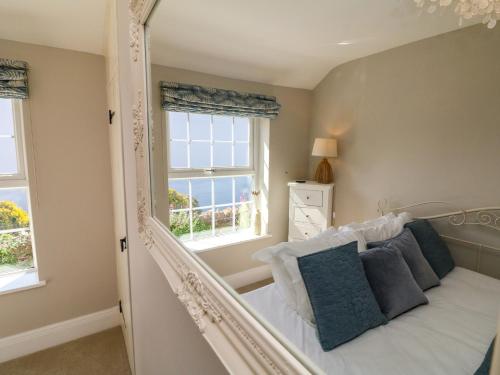 a bedroom with a bed and two windows at Applestow in Bideford