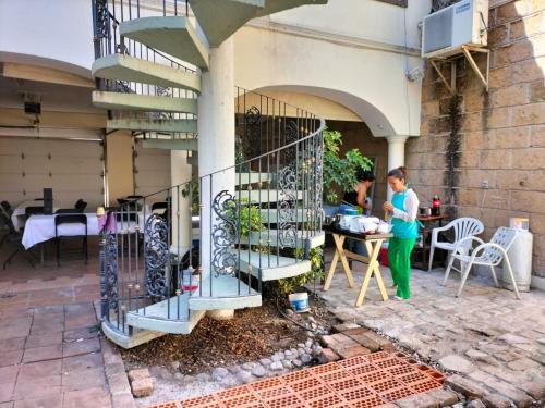 a woman standing next to a building with a spiral staircase at Hotel Teui Formarte Grupos in Celaya
