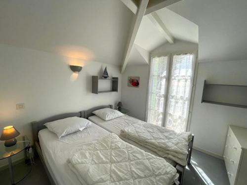 une chambre avec deux lits et une fenêtre dans l'établissement Maison chaleureuse avec piscine, proche forêt et plage, à Saint Jean de Monts - Wifi gratuit - FR-1-323-441, à Saint-Jean-de-Monts