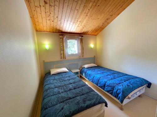 Cette petite chambre dispose de 2 lits et d'un plafond en bois. dans l'établissement Maison proche forêt, 2 chambres, terrasse et parking - 6 personnes, St Jean de Monts - FR-1-323-523, à Saint-Jean-de-Monts