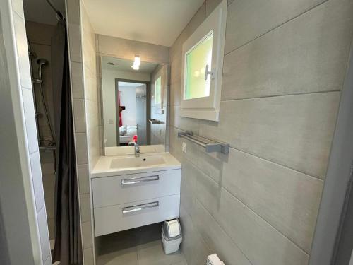 une salle de bain avec un lavabo et un miroir dans l'établissement Maison chaleureuse avec piscine, proche forêt et plage, à Saint Jean de Monts - Wifi gratuit - FR-1-323-441, à Saint-Jean-de-Monts