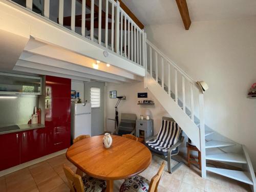 une salle à manger avec une table et un escalier dans l'établissement Maison de vacances avec piscine, terrasse et coin détente en forêt, proche plage! - FR-1-323-486, à Saint-Jean-de-Monts
