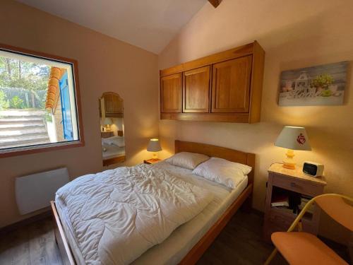 une petite chambre avec un lit et une fenêtre dans l'établissement Maison de vacances avec piscine, terrasse et coin détente en forêt, proche plage! - FR-1-323-486, à Saint-Jean-de-Monts