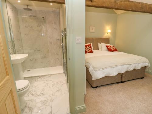 a bedroom with a bed and a shower and a toilet at The Coach House in Newcastle upon Tyne