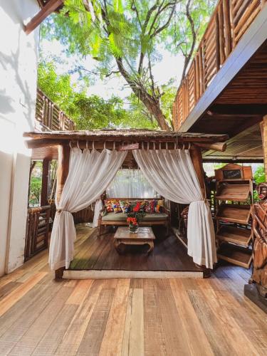 a living room with a couch and a tree at Pousada João Sol in Praia do Forte