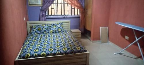 a bedroom with a bed in a room with a window at Owalester house in Abeokuta