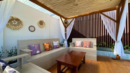 Cette chambre comprend une table et des bancs avec des oreillers. dans l'établissement Rautani Sembalun, à Sembalun Lawang