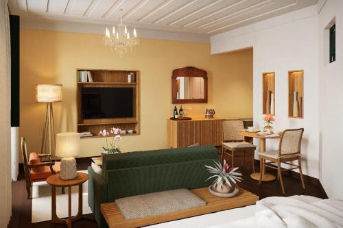 ein Wohnzimmer mit einem grünen Sofa und einem Tisch in der Unterkunft Hotel Villa Bahia in Salvador