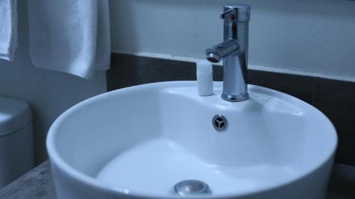 a white sink with a faucet in a bathroom at Punto Madero Hotel & Plaza in Mocorito
