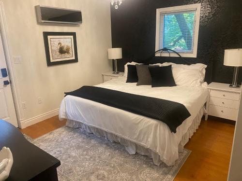 a bedroom with a large bed with black and white pillows at North of Avon B&B Suites in Stratford