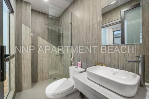 a bathroom with a toilet and a sink and a mirror at NNP Apartment Beach. in Da Nang