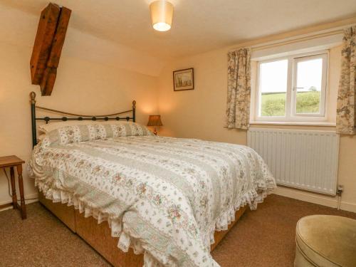 ein Schlafzimmer mit einem großen Bett und einem Fenster in der Unterkunft The Cottage in Bideford