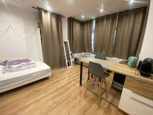 Cette chambre comprend un bureau et un lit. dans l'établissement Charmant Studio Rénové à Deux Pas de la Plage et des Commerces - FR-1-674-44, à Berck-sur-Mer