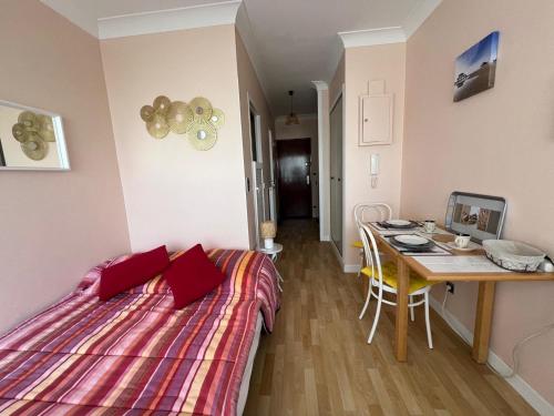 une petite chambre avec un lit et une table dans l'établissement Appartement cosy hyper centre d'Arcachon, proche plage et commerces - FR-1-474-262, à Arcachon