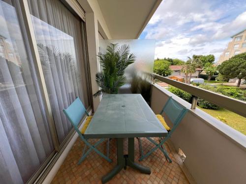 une table et des chaises sur un balcon avec une plante dans l'établissement Appartement cosy hyper centre d'Arcachon, proche plage et commerces - FR-1-474-262, à Arcachon