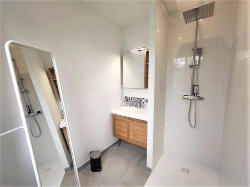 une salle de bain avec une douche, un lavabo et un miroir dans l'établissement Maison 8 pers, proche plage et commerces, jardin, barbecue, équipements bébé, linge inclus - FR-1-639-122, à Arzon