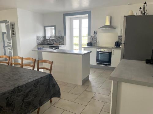 une cuisine avec une table et un comptoir dans l'établissement Grande maison avec piscine privée, 7 chambres et vue sur la campagne - FR-1-410-444, à Chemiré-en-Charnie