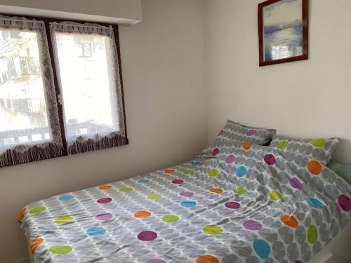 - une chambre avec un lit avec une couette et 2 fenêtres dans l'établissement Appartement 2 pièces avec balcon, parking, proche plage et lac à Villers-sur-Mer - FR-1-712-81, à Villers-sur-Mer