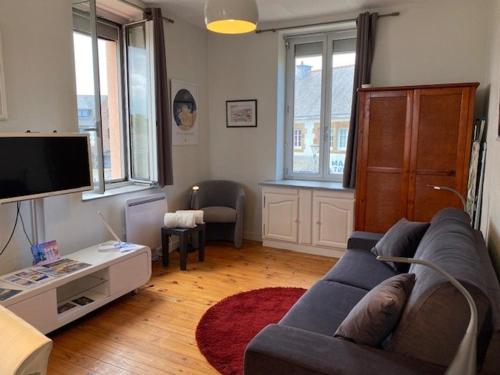 un salon avec un canapé et une télévision dans l'établissement Studio Lumineux Proche Plage et Commerces – Tout Équipé, Parking Gratuit - FR-1-542-66, à Trégastel