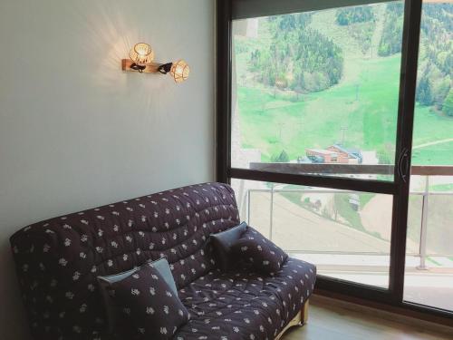 un salon avec un canapé et une grande fenêtre dans l'établissement Studio 2 Personnes au Pied des Pistes avec Balcon - Villard-de-Lans - FR-1-689-134, à Villard-de-Lans