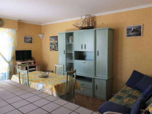 un salon avec une table et une armoire dans l'établissement Appartement T2 à Royan - Plage de Pontaillac - 2 adultes/2 enfants, terrasses, parking, proche commerces - FR-1-738-32, à Royan