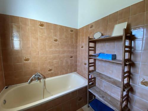 La salle de bains est pourvue d'une baignoire et d'une étagère. dans l'établissement Villa à Cavalaire-sur-Mer: proche plages, jardin, 3 chambres, balcon, terrain de pétanque - FR-1-100-338, à Cavalaire-sur-Mer