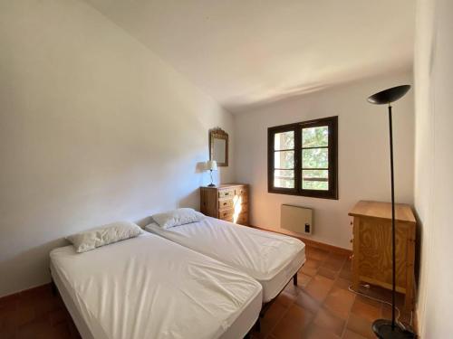 une chambre avec un lit blanc et une fenêtre dans l'établissement Villa à Cavalaire-sur-Mer: proche plages, jardin, 3 chambres, balcon, terrain de pétanque - FR-1-100-338, à Cavalaire-sur-Mer