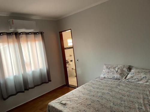 a bedroom with a bed and a mirror and a window at Casa Grande Centro in Rio Verde
