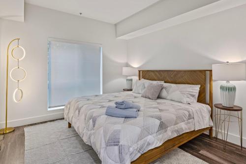a white bedroom with a large bed and a window at 11 Best Walk location of SM in Los Angeles