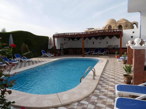 a swimming pool in a patio with blue chairs at Villa Quiet Place in Luxor