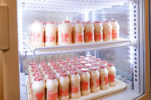 an open refrigerator filled with bottles of milk at Dormy Inn Chiba City Soga in Chiba