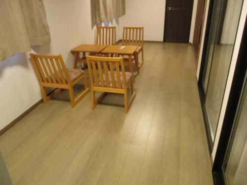 a dining room with a wooden table and chairs at 萩つばき in Hagi
