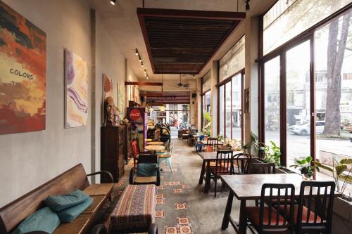 um restaurante com mesas, cadeiras e janelas em 9 Hostel and Bar em Ho Chi Minh