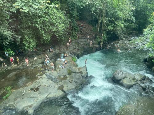 a group of people swimming in a river at Hotel Tierra de Volcanes in San Ramón