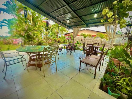 a patio with a table and chairs and plants at Hotel Tierra de Volcanes in San Ramón