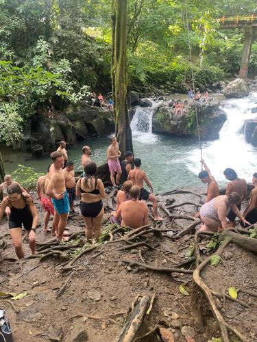a group of people in the water at a waterfall at Hotel Tierra de Volcanes in San Ramón